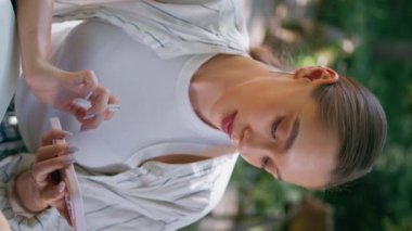 Rahat kız akıllı telefonuyla internetten park masasında otururken bilgi arıyor. Fotokopi defterine cep telefonundan not yazan düşünceli bir kadın öğrenci eğitici görevleri dikey olarak yerine getiriyor..