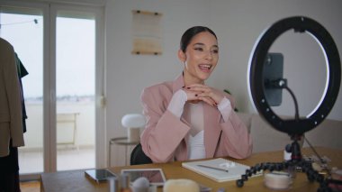 Güzellik blogcusu beyaz dairede akıllı telefon kamerasıyla konuşan aboneleri selamlıyor. Kapanış duygusal kadın ev stüdyosunda canlı yayın yapan içerik yaratıyor. Mutlu kız içeride özel ders kaydı yapıyor.