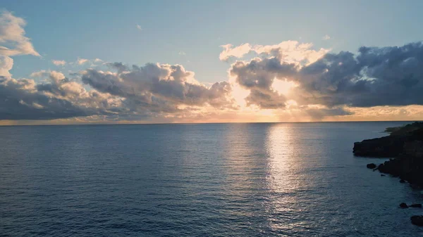 Sunrise marine nature surface drone view. Picturesque calm morning ocean with light waves super slow motion. Pastel sun beams breaking thunder clouds reflecting water expanse. Endless sea horizon