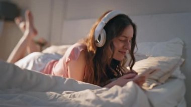 Evde müzik dinleyen rahat bir bayan. Tasasız genç kadın güneş ışığında akıllı telefon kullanarak istirahat ediyor. Neşeli güzel kız kulaklıkla şarkı söylemekten hoşlanıyor. Mutlu genç sörfçü cep telefonu çalma listesi