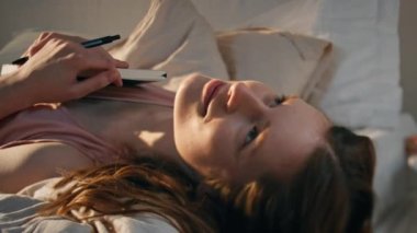 Güler yüzlü kız, güneş ışığında yatağında uzanıyor. Çekici bir kadın günlük tutuyor ve yalnız zaman geçiriyor. Romantik genç, mutlu anları anımsıyor. Neşeli kadın kucaklama kitabı 