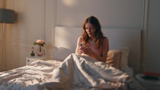 Sabah Güneşinde Uyanık Bir Kadın Telefon Daktilo Ediyor Yatakta Dinlenen — Stok video