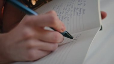 Eller günlük tutarken yakın plan çekimde. Mutlu gülümseyen kız elinde kalem yazma planları tutarak kişisel günlüğünde duygularını ifade ediyor. Yaratıcı fikirleri not eden neşeli, güzel bir kadın. Anılar yaşam tarzı konsepti