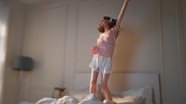 Glücklicher Teenager Der Mit Kopfhörern Ins Bett Springt Unbekümmertes Mädchen — Stockvideo
