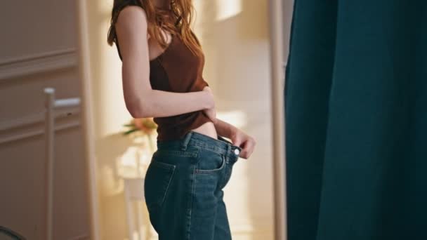 鏡の反射クローズアップで大きなジーンズを試している女性の体 胃腹の経験をチェック不幸なスキニーガールは 体重が障害を食べる問題を増加させます フラストレーションされたストレスモデル スリムチェックの進捗状況 — ストック動画