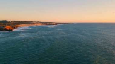 Sakin deniz sörfü akşam doğası ağır çekimde. Sakin okyanus dalgalarıyla yıkanan resimli hava tepeleri. Köpüklü dalgalar gün batımında yüzeye çıkıyor. Vahşi terk edilmiş kıyı manzarası konsepti