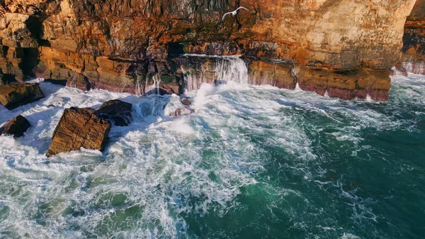 无人机看到危险的海岸岩石 巨浪冲击在石头上 在火山悬崖峭壁上喷出的暴风雨般的泡沫水 海鸥在深海表面飞行 慢动作的海洋景观 — 图库照片