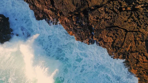 顶部看发泡的海洋撞击火山海岸岩石 使气泡白色泡沫以超慢速运动 无人机在黑暗的悬崖峭壁上喷射出惊人的强大海水 危险的海景 — 图库照片