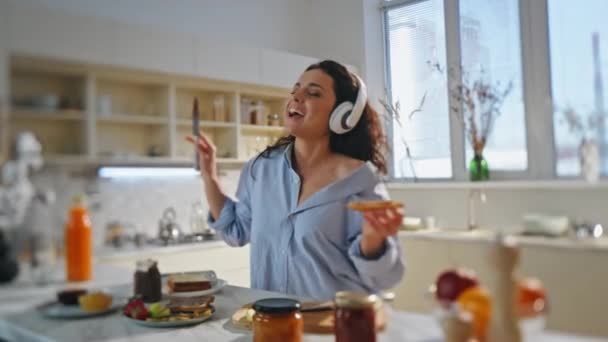 Дівчина Готує Їжу Навушниках Співаючи Вздовж Улюбленої Пісні Затишній Кухні — стокове відео