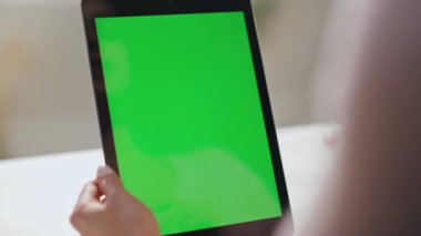 Yeşil ekran tablet web kamerasıyla konuşan bir kadın kapalı mekanda video konferansı yapıyor. Ofisteki bilgisayarla tanınmayan iş kadını videosu arıyor. Krom anahtar aygıtında çalışan kız