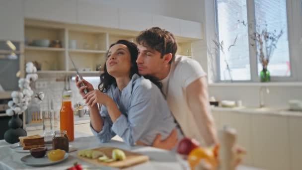 一对快乐的夫妇正在谈论舒适的厨房烹调家庭早餐 浪漫多情的丈夫拥抱美丽的妻子 准备早上的美味佳肴 婚姻关系幸福的概念 — 图库视频影像