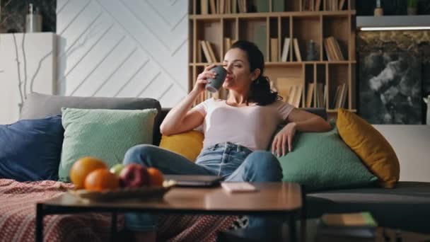 Zrelaksowana Kobieta Freelancer Pije Herbatę Siedząc Samotnie Kanapie Spokojny Szczęśliwy — Wideo stockowe