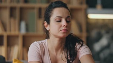 Gülümseyen kadın akıllı telefon ekranına bakıyor ve evde iyi haberlerle mesajlar okuyor. İçerideki iletişim için modern telefonu kullanan çekici, rahat bir kızın portresi. Modern hayatta teknoloji.