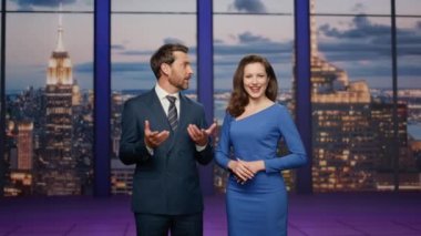 Stüdyo televizyon kanalında gülümseyen dost canlısı sunucular. Neşeli haber spikerleri son dakika gelişmelerini bildiriyor. Mutlu spikerle konuşan sakallı spiker..