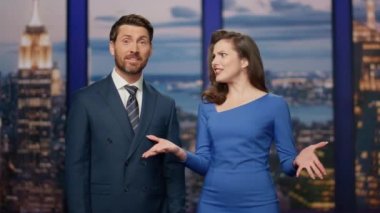 Birkaç sunucu multimedya kanal stüdyosundan son dakika gelişmelerini bildiriyor. Güncel dünya olaylarını yayınlayan profesyonel dost sunucular. İki gülümseyen muhabir havada günlük bilgileri tartışıyor