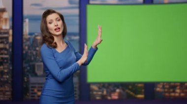 Kendine güvenen TV sunucusu, medya kanalı stüdyosundaki yeşil ekranda haber sunuculuğunu yapıyor. Güzel, gülümseyen kadın haber spikeri model monitörde güncel bilgileri aydınlatıyor. Televizyon endüstrisi