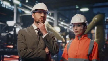 Erkek patron, modern üretim ekipmanlarıyla fabrikayı inceliyor kadın uzmanla konuşuyor. Düşünceli iş adamı el sıkışan kadın mühendis imalattan memnun. Ortaklık kavramı.