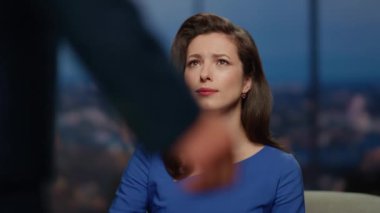 Modern kanal stüdyosunun sunucusunu sunan ciddi bir haber sunucusu. Güzel kadın sunucu, merhametle erkeğe bakıyor. Üzgün spiker canlı yayında ziyaretçi televizyon programıyla konuşuyor..