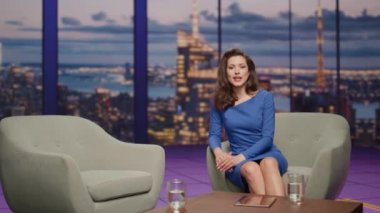 Güzel sunucu, stüdyo akşam canlı TV programında konuk sunar. Gülümseyen adam televizyon kanalında oturuyor. Birbirlerine iltifat eden iki insan eğlence programı başlatıyorlar..