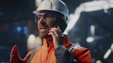 Fabrika işçisi endüstriyel tesislerde cep telefonundan konuşuyor. Portre üniformalı, kendinden emin mühendis akıllı telefondan üretim işini tartışıyor. Sakallı profesyonel teknisyen iş arkadaşlarını arıyor..
