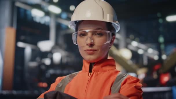 专业工程师手牵手在创新工厂的肖像 熟练的女工业员工期待相机与微笑特写 头盔制造业工人站在生产现场 — 图库视频影像