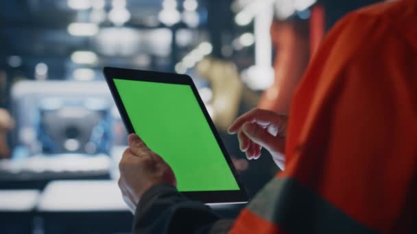闭塞技术人员模拟平板电脑检查生产信息 穿着制服的无名工程师在工厂里拿着绿色屏幕电脑 专业工人用手触摸着色键小玩意 — 图库视频影像