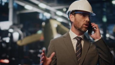 Metalurji tesisinde fabrika müdürünün konuşan telefonu. Ciddi bir fabrika mühendisi akıllı telefonla üretim sürecini tartışıyor. Endişeli yapım uzmanı atölyedeki cep telefonu görüşmesini sonlandırdı.