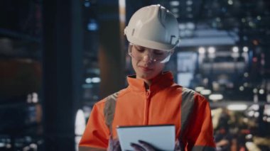 Tabletli kadın kontrolör. Üretim metallerini yakından inceliyor. Güvenilir bayan müfettiş fabrikada duran ekipman kalitesini kontrol ediyor. Kask üniformalı yetenekli teknisyen bilgisayar işinde.