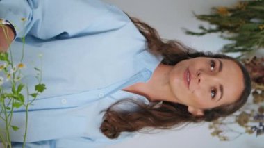 Neşeli çiçekçi küçük işletmeci dükkanında dikey olarak çalışıyor. Yakın plan mutlu iş kadını güzel bir buket düğün hediyesi hazırlıyor. Çekici kadın konuşmaları çiçekçide müşterilere yardımcı olur. Bitki işi konsepti.