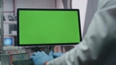 Modern gelişmiş laboratuvarda yeşil ekran bilgisayar yazan bir doktor. Tanımlanamayan bilim adamı araştırma verilerini kroma anahtar bilgisayara giriyor. Laboratuvarda klavye yazan eldivenli profesyonel kimyager..