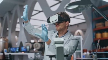 İleri düzey laboratuvarda fütüristik simülasyonla çalışan VR gözlüklü kimyager. Ciddi bir bilim adamı bilimsel araştırmalar için sanal gerçeklik kulaklığı kullanıyor. Laboratuar biyomühendisleri arayüze dokunuyor.