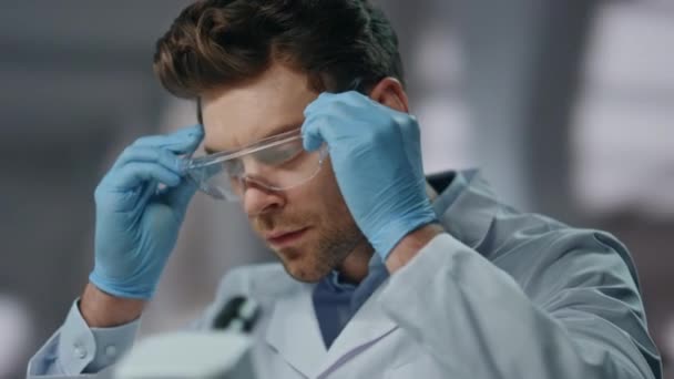 Vědec Bezpečnostními Brýlemi Zkoumat Léky Pokročilé Laboratoři Zblízka Vážný Muž — Stock video
