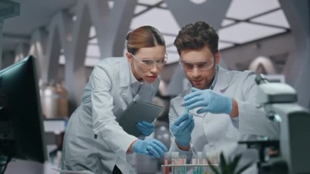Dwa Aptekarze Patrząc Próbki Leków Innowacyjnych Zaawansowanym Laboratorium Zbliżenie Kilku — Wideo stockowe