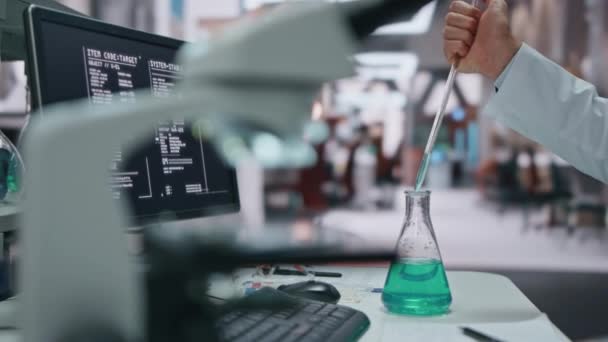实验室密闭实验中 科学家们从玻璃瓶中手工灌满了水壶 认真的化验室技术员把药品样品放在显微镜下 研究药物的人类生物技术专家 — 图库视频影像
