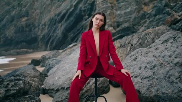 Modelo Moda Sedutor Sentado Costa Rochosa Vestindo Terno Vermelho Sexy — Vídeo de Stock