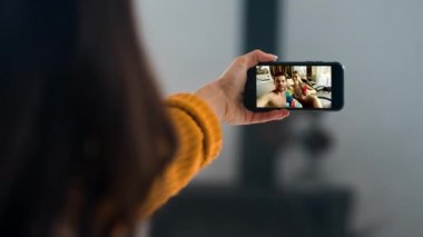 Mutlu arkadaşlar cep telefonunu çevrimiçi arıyor. Yakından el sallayan akıllı telefon ekranını tutuyor. Tanımlanamayan bir kadın internet konferans uygulaması kullanarak neşeli bir aileden bahsediyor. Rahatlamış insanlar spa tatilinde dinleniyor..