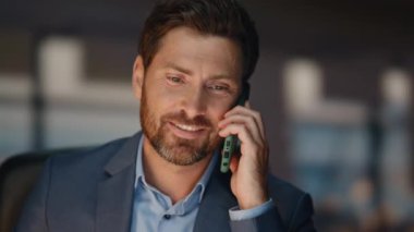 Kapanışta mutlu iş adamı cep telefonunu arıyor ve akşam ofisini arıyor. Karanlık iş yerinde kendine güvenen bir yönetici akıllı telefondan bahsediyor. Şık patron telefon görüşmesinde gülümseyen danışman müşteri.