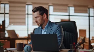 Odaklanmış yönetici, hafif iş yerindeki iş belgelerini kontrol ediyor. Ciddi sakallı bir adam modern ofis içinde kahve yudumluyor. Sakin zengin iş adamı masamda tek başına oturuyor.