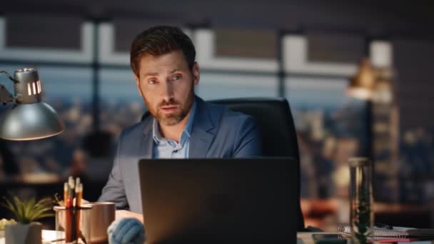 商人视频聊天笔记本电脑在夜景办公室特写 重点是让客户虚拟会议做笔记 严重的男性上司单独在黑暗的室内进行计算机视频交流 — 图库视频影像