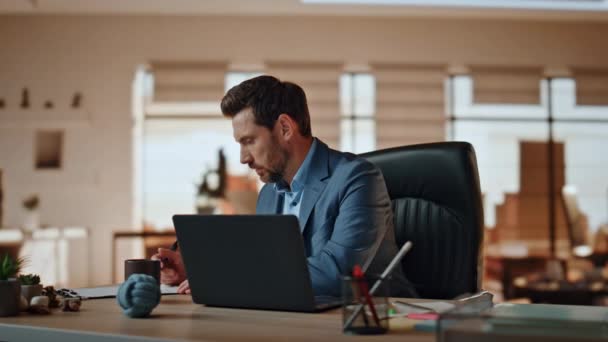 有重点的经理在轻松的工作场所特写笔记 一个大胡子的男人在现代办公室里喝着咖啡 沉着沉着的会计师独自坐在办公桌前填写财务单据 — 图库视频影像