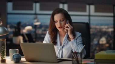 Girişimci bayan gece kabinesinde çalışan akıllı telefondan konuşuyor. Gülümseyen dost canlısı kadın panoramik pencere ofisinde elinde kalemle cep telefonu pazarlığı yapıyor. Pozitif yönetici gece geç saatlere kadar çalışıyor. 