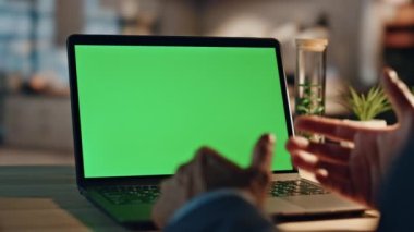 Direktör Chromakey bilgisayarını akşam çalışma masasına yakın çekimde teslim ediyor. Kimliği belirsiz bir adam yeşil ekran laptop ofisinde video konferansı yapıyor. Modelleme aygıtında iş adamı konuşuyor 