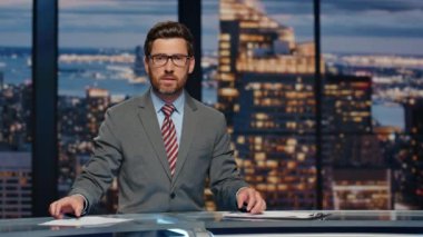 Ciddi haber spikeri akşam haberlerini sunuyor. Televizyon stüdyosu kapanıyor. Kendine güvenen bir adam aydınlatma dünyasının politik durumunu sunuyor. Profesyonel televizyon yayın konsepti