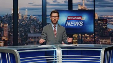 Sunucu stüdyodan son dakika haberleri veriyor. Profesyonel gazeteci canlı yayında günlük olayları anlatıyor. Sakallı erkek haber spikeri televizyon kanalında ekranda açılış yapıyor. 