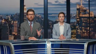 Karizmatik TV muhabirleri akşam haberlerini kapatıyorlar. Canlı yayında televizyon izleyicilerine gülümseyen çift sunucuları. İki dost canlısı sunucu kablolu kanalda haber yayınını tartışıyor.
