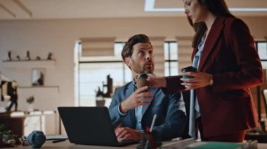 Bir kadın, iş arkadaşını sabah ofisinde bir araya getiriyor. İş arkadaşları modern işyerindeki kağıt bardaklardan sıcak çay içmekten bahsediyorlar. İki ortak dizüstü bilgisayara bakma projesini tartışıyor 