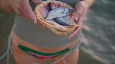 Nehir kenarında el ele tutuşan balıklar. Yaz tatilinde kırsal nehirde balık tutan bir kadın. Tanınmayan balıkçı kız, akşam küçük bir avlanma sergiliyor. Hobi kamp konsepti..