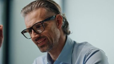 CEO 'nun işyerinde tek başına oturmasından endişe ediyorum. Stresli iş adamı üzgün gözlüğünü çıkartıyor. Mutsuz erkek bilgisayar ekranına bakıyor cam ofis içinde kötü haber e-postaları okuyor. 