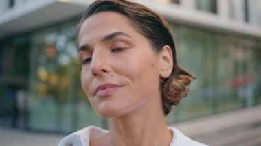 Şehir merkezinde gülümseyen portre yöneticisi kadın. Modern binanın arka planında beyaz gömlekle poz veren mutlu ofis çalışanı. Neşeli orta yaşlı iş kadını. Kameraya bak. İyi tatiller. 