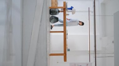 Sanat galerisinde yürüyen genç bir kadın. Çağdaş müzede sergi sanatları sergileyen ziyaretçi. Yoga merkezini dikey olarak ziyaret eden düşünceli bir kız. Açılıştan önce mal sıralama yöneticisi.